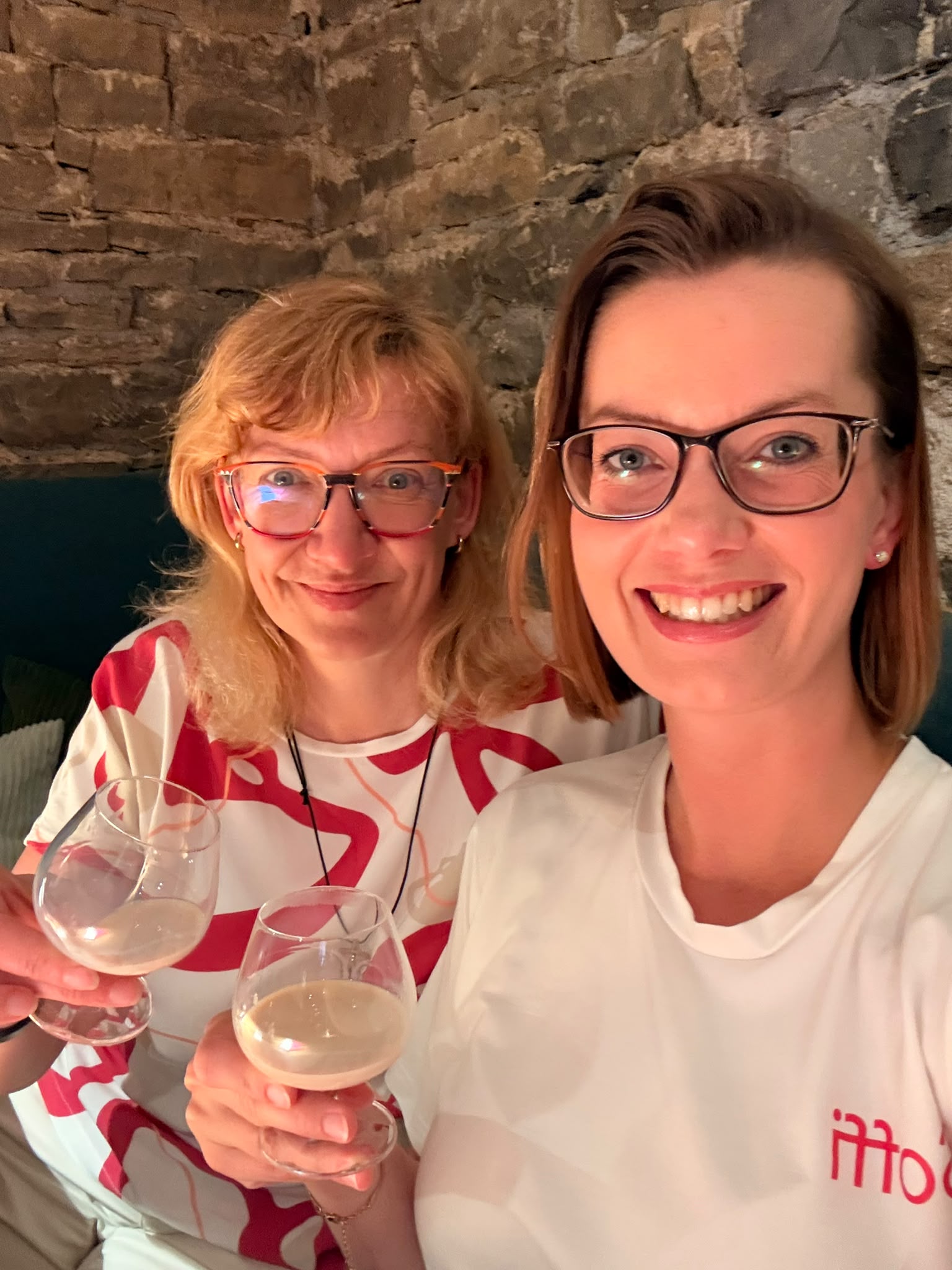 Zwei lächelnde Frauen halten beim MindWeib-Netzwerktreffen ihre Weingläser in die Kamera.